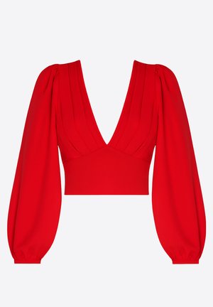 Blouse rouge courte avec un décolleté en V profond, manches longues bouffantes resserrées aux poignets, et plis verticaux cousus sur le devant du corsage.