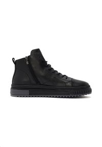 Baskets montantes en cuir noir avec fermeture éclair latérale, lacets noirs, semelle épaisse rainurée et languette de tirage sur fond blanc.