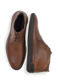 Zapatos de cuero marrón con acabado texturizado, que presentan un perfil bajo, punta redondeada, diseño de cordones y suela de goma negra.