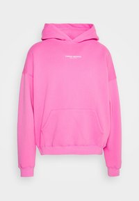 Sudadera rosa de gran tamaño hecha de tela suave, con un bolsillo frontal, puños acanalados y un estampado de "PEOR COMPORTAMIENTO" en el pecho.