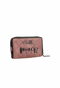 Monedero acolchado rosa con un zipper negro, que presenta detalles plateados, texto decorativo y pequeñas gemas. Forma rectangular con una textura suave.