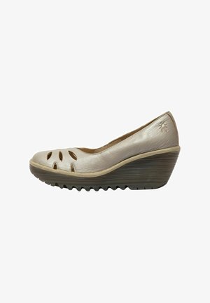 Béžová kožená wedge obuv s vykrojenými detaily na špičce. Texturovaná gumová podrážka a hladký, zakřivený silueta. Jemný akcent loga na patě.