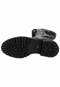 Botte en cuir noir avec une semelle en caoutchouc texturée, présentant un motif de semelle robuste et des détails en lacets le long de l'arbre.