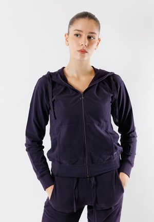 Navy zip-up hoodie in soft fabric with a relaxed fit, featuring a hood, drawstrings, and front pockets. Designed for comfort and ease of wear.