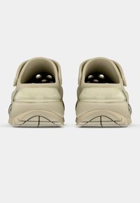 Par bežnih Crocs šol, prikazanih s hrbtne strani, z teksturiranimi podplati in ventilacijskimi luknjicami na vrhu.