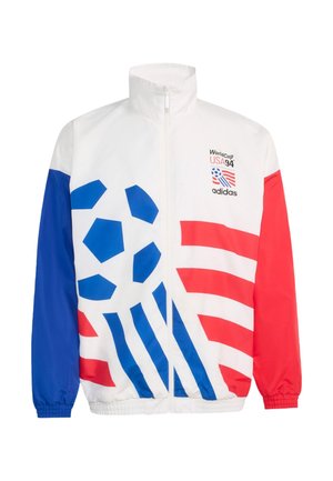 Weiße Zip-Up-Jacke mit blauen und roten geometrischen Fußballmustern, roten und blauen Ärmeln und dem Logo "World Cup USA 94 adidas" auf der Brust.