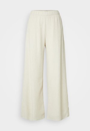 Pantaloni evazați dintr-un material texturat, de culoare crem. Au o talie elastică și o siluetă fluidă. Potriviți pentru ținute casual.