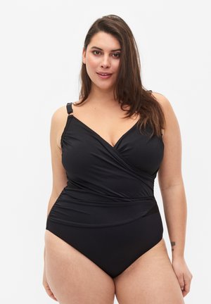 Costume da bagno intero nero con design avvolgente, spalline regolabili e tessuto morbido e testurizzato. Presenta una schiena bassa e un colore uniforme.