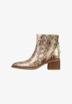 Bottine à imprimé serpent métallique avec un bout pointu, une semelle intérieure rembourrée et un talon mi-hauteur superposé. Fermeture éclair latérale pour un enfilage facile.