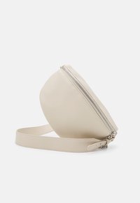 Borsa a tracolla color crema con forma arrotondata, texture liscia, chiusura a zip superiore e una tracolla piatta e regolabile. Accenti in hardware argentato.