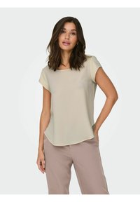 Lys beige bluse med korte ermer og firkantet utringning. Glatt, lett stoff med avslappet passform og buet fald.