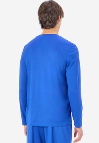 Blå skjorta med lång ärm i ett slätt tyg. Har en rundad halsringning och en avslappnad passform, passar bra för vardagsbruk.