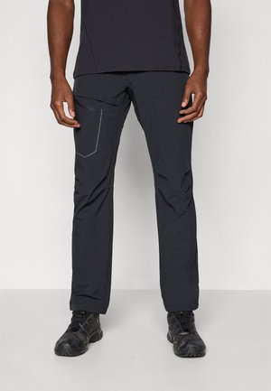 Black technical pants with a slim fit, feature a zippered pocket, subtle stitching accents, and are made from lightweight, durable material.