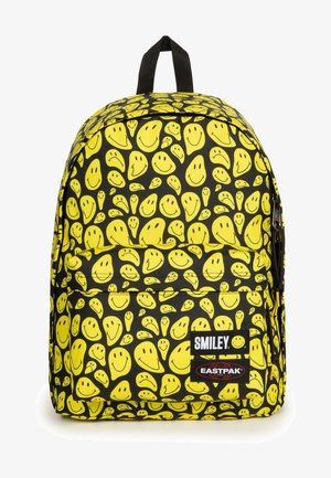 Batoh s černou tkaninou a vzory žlutých smajlíků, nastavitelnými popruhy a přední kapsou na zip. Štítky: SMILEY a EASTPAK.