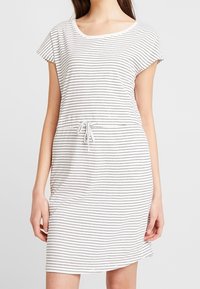 Randig kortärmad klänning i vitt och marinblått, med justerbart dragsko i midjan och en avslappnad passform. Mjuk, lättviktsmaterial.