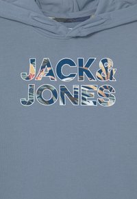 Mikina s kapucí ve světle modré barvě s nápisem "JACK & JONES" v duhových vzorech, texturovaný povrch a standardní střih.