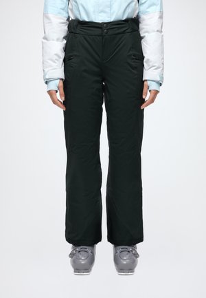 Un mannequin porte un pantalon de ski noir à poches zippées et des chaussures de ski grises, avec une veste bleu pâle et blanche.