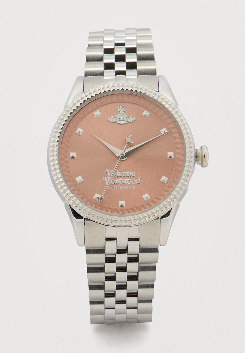 Sudraba Vivienne Westwood pulkstenis ar rozā zelta ciparnīcu, piramīdas formas stundu rādītājiem un no nerūsējošā tērauda savienotu siksniņu, kas rāda laiku 10:10:35.