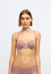 Mauve BH med glat, elastisk stof, bøjleunderstøttelse og tynde justerbare stropper. Har let polstrede skåle og en sømløs design.