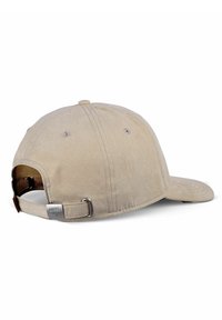 Beige Baseballcap mit gebogenem Schirm, aus weichem Material. Verfügt über einen verstellbaren Riemen auf der Rückseite und ein metallisches Logo-Detail. Keine sichtbaren Muster.