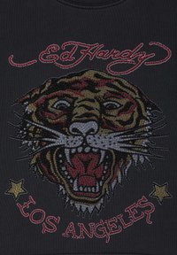 Svart t-shirt med en tiger grafik dekorerad med rhinestones, röda och gyllene accenter, samt "Ed Hardy" text ovanför och "Los Angeles" nedanför.