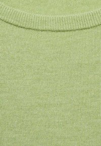 Svetlozelena pletena jopica z ribanim okroglim izrezom, fino teksturo in enakomernim šivanjem z subtilnimi barvnimi odtenki.