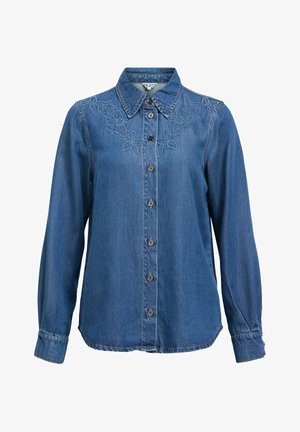 Sininen farkkupaita, jossa pitkät hihat ja kukkakirjailu pääntien ja kauluksen ympärillä.