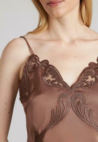 Camisón de satén marrón con bordado decorativo a lo largo del escote y las tirantes, presentando intrincados patrones en espiral y un suave brillo.