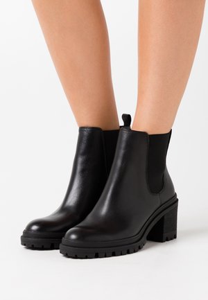 Black leather ankle boots with elastic side panels, rounded toe, and chunky block heel. Textured sole for traction.