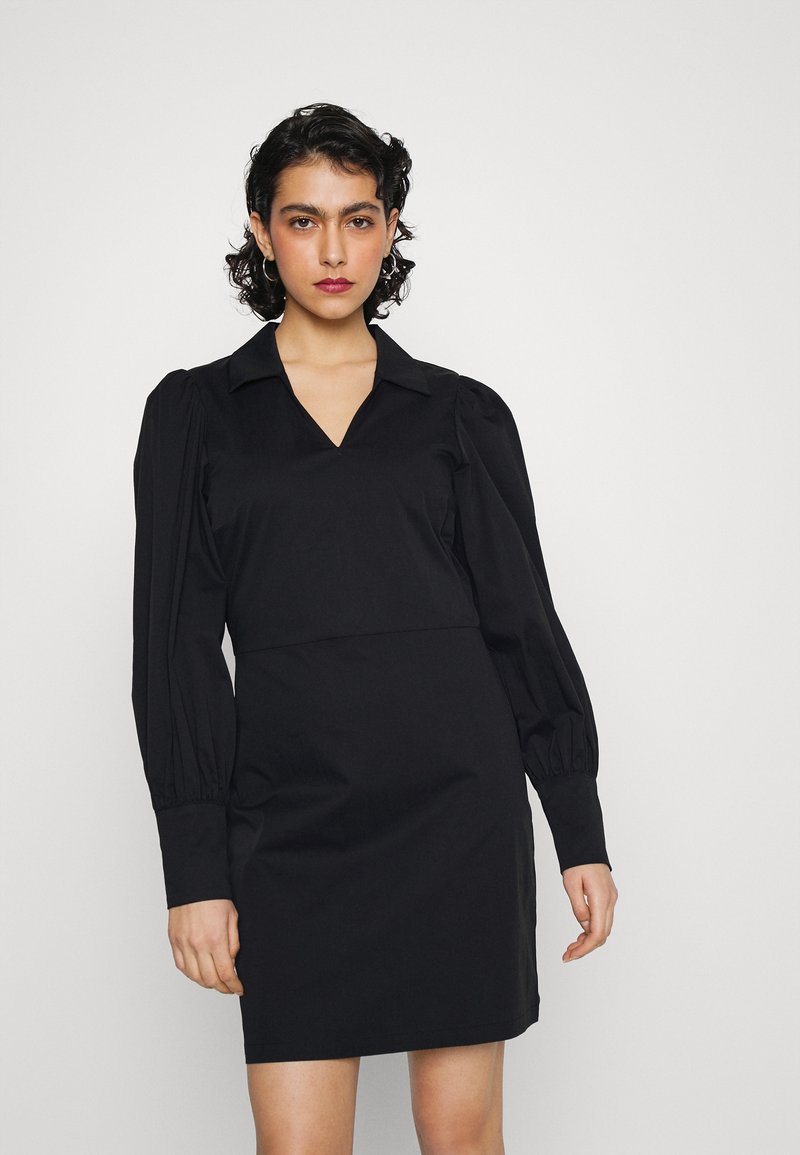 Vestido preto com decote em V e mangas bufantes longas. Feito de um tecido suave, com uma cintura ajustada e barra reta. Sem padrões ou detalhes visíveis.