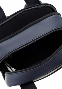 Tyrkysově modrý batoh s hladkým koženým exteriérem, s zipovým uzavíráním, elegantním designem a interiérem podšitým látkou.