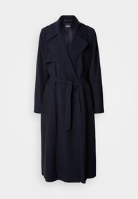 Long trench-coat bleu marine foncé avec larges revers, ceinture à la taille et poches latérales, présenté sur un fond clair uni.