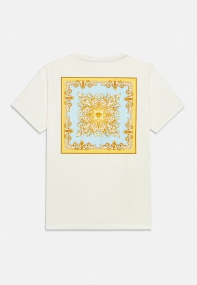 Bílé bavlněné tričko s čtvercovým motivem na zádech. Design obsahuje složité zlaté a modré vzory v ozdobném stylu.