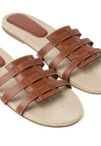 Braune Leder-Sandalen mit Slides, woven Oberteil, strukturierte beige Jute-Innensohle und feine Nähte. Flache Gummisohle.