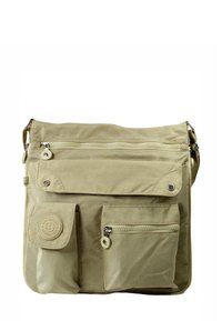 Sac bandoulière beige en toile avec plusieurs poches zippées et à rabat, une finition texturée et un patch logo sur le devant.