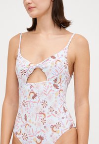 Maillot de bain une pièce en bleu clair avec un imprimé floral et arc-en-ciel, présentant des bretelles fines et un détail coupé à l'avant avec un design noué.