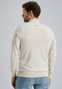 Hellgrauer Pullover mit hohem Kragen, gerippten Ärmelbündchen und Schulterakzenten. Verfügt über eine glatte Textur und minimalistische Details auf der Rückseite.