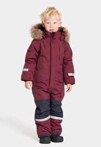 Bordeaux snödräkt med pälsfodrad huva, reflekterande detaljer och svarta nedre partier. Tillverkad av väderbeständigt material, designad för värme.