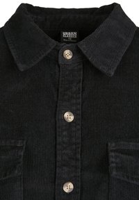 Chemise en velours côtelé noire avec col, trois boutons ronds beige et deux poches poitrine, taille XS, fabriquée au Pakistan.