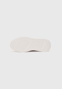 White sneaker sole with textured patterns and the "GUESS" logo embossed. Features a smooth finish and contoured design for comfort.
