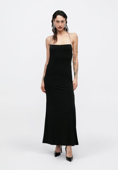 Μαύρο midi φόρεμα με ευθεία γραμμή λαιμού, λεπτές αλυσίδες για τιράντες και εφαρμοστή σιλουέτα. Λείο υλικό, μινιμαλιστικός σχεδιασμός και χωρίς σχέδια.