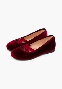 Bailarinas de terciopelo en rojo oscuro con punta redonda, que presentan un detalle recortado y un lazo a juego. Textura suave y diseño minimalista.