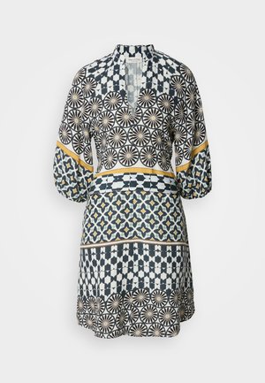Patterned dress featuring geometric designs in navy, white, and yellow. Long sleeves, V-neckline, and a flared silhouette with distinct sections.