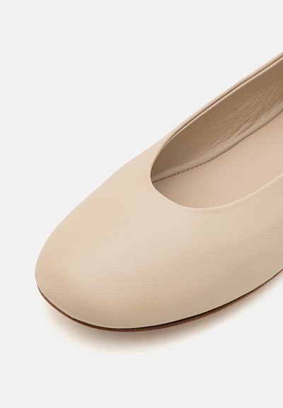 Beige leren ballerina met een ronde neus, een glad oppervlak en een lage vamp. Het interieur is voorzien van een zachte voering.