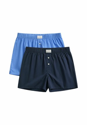 Twee paar boxershorts met elastische taille, één lichtblauw en één donker marineblauw, elk met knopen aan de voorkant en een klein label.