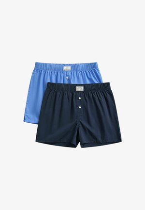 Due paia di boxer con vita elastica, uno azzurro chiaro e uno blu scuro, entrambi con bottoni frontali e una piccola etichetta.