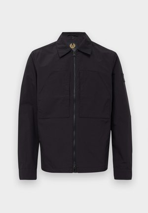 Black zip-up jacket with two front flap pockets, long sleeves, a collar, and a patch on the left upper sleeve.