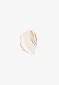 Texture de crème beige, finition lisse et brillante, avec une consistance légèrement épaisse, sur fond blanc.