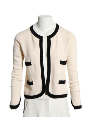 Cardigan crème à manches longues avec bordures noires le long des bords, des poches et des poignets, présenté sur un buste de mannequin blanc.