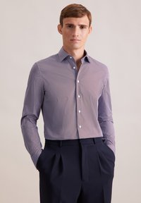 Langarmshirt in een geometrisch patroon in paars en wit, met knoopsluiting en van katoen, gecombineerd met donker op maat gemaakte broeken.